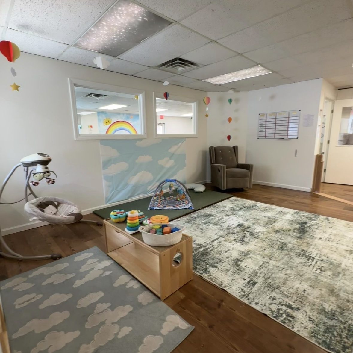 Photo of Infant room with rocking chair, toys, and bouncers