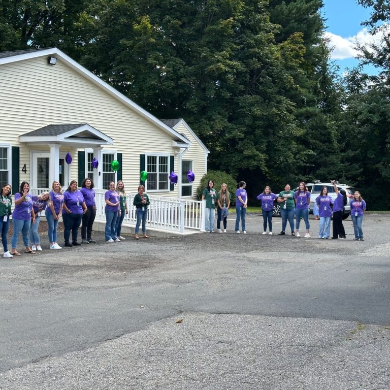 Burlington Academy Teachers smiling in front of Junior Academy Building
