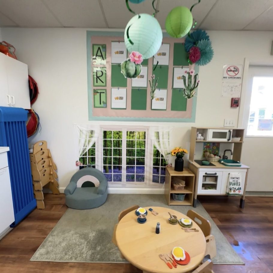 Play area including kitchen, play food, decorations on walls and a comfy rug.