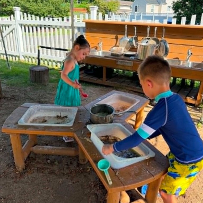 Children playing outside in sensory bins